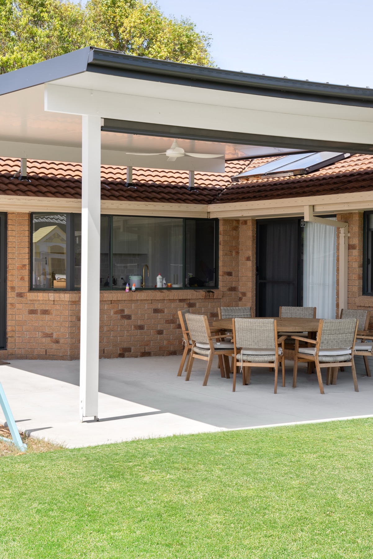 After — a finished PatioHub insulated roof with a ceiling fan, over neat concrete