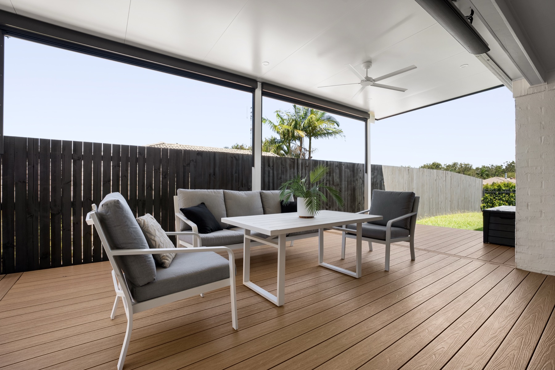 Insulated patio over a composite timber deck, with ceiling fan and café blinds