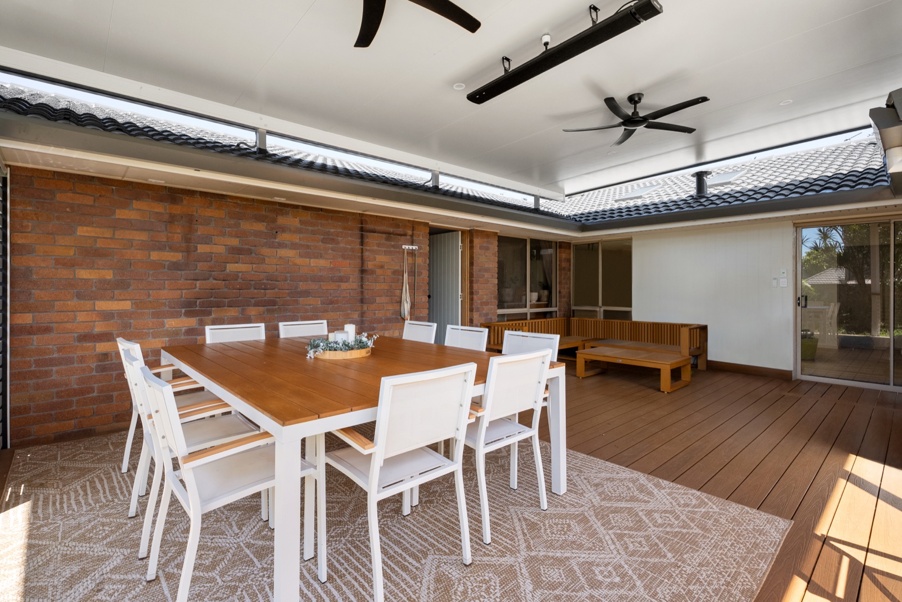 Insulated patio over a timber deck, with dining setting, ceiling fans and strip heaters