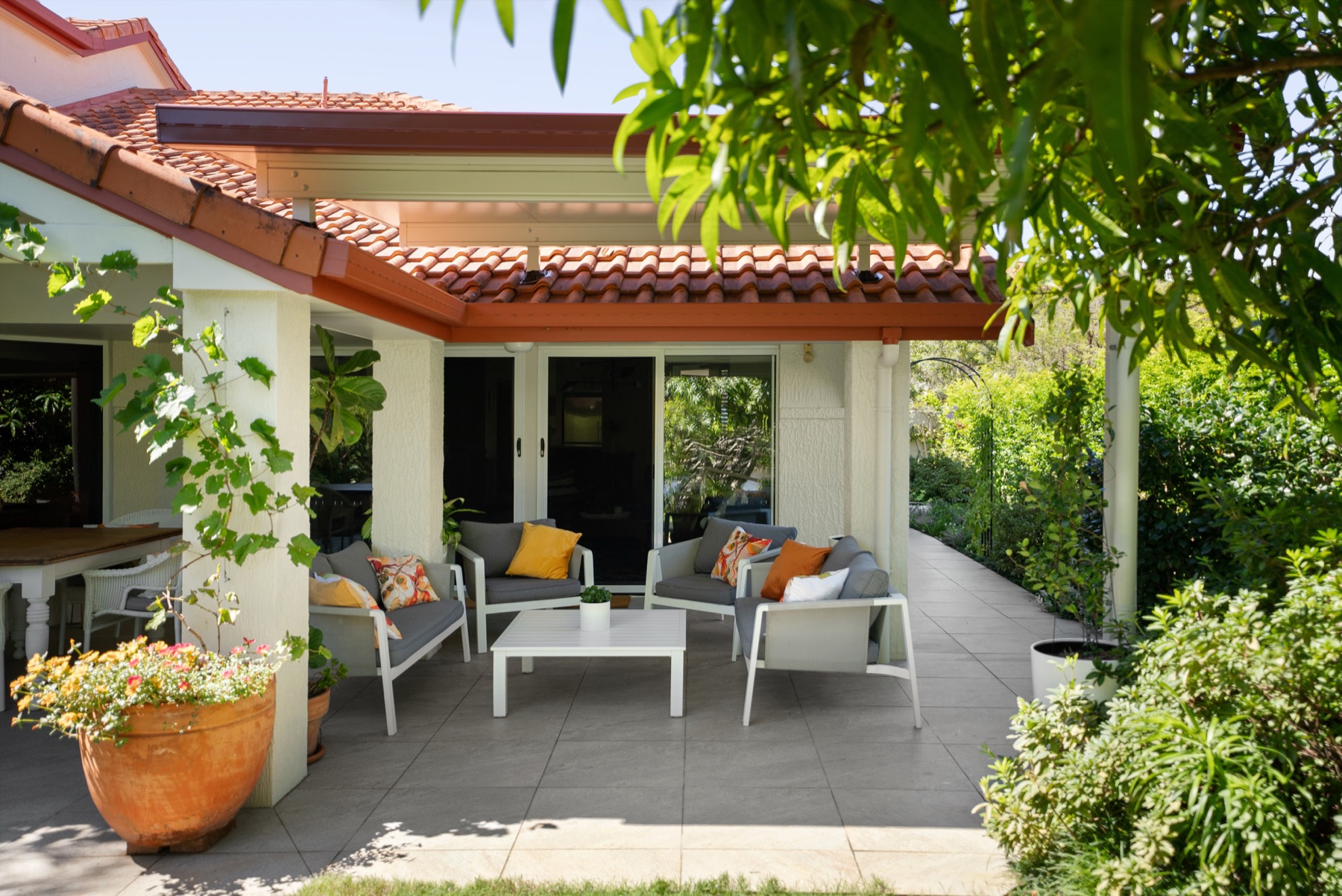 Insulated flyover patio over tiled outdoor living, on a rendered home
