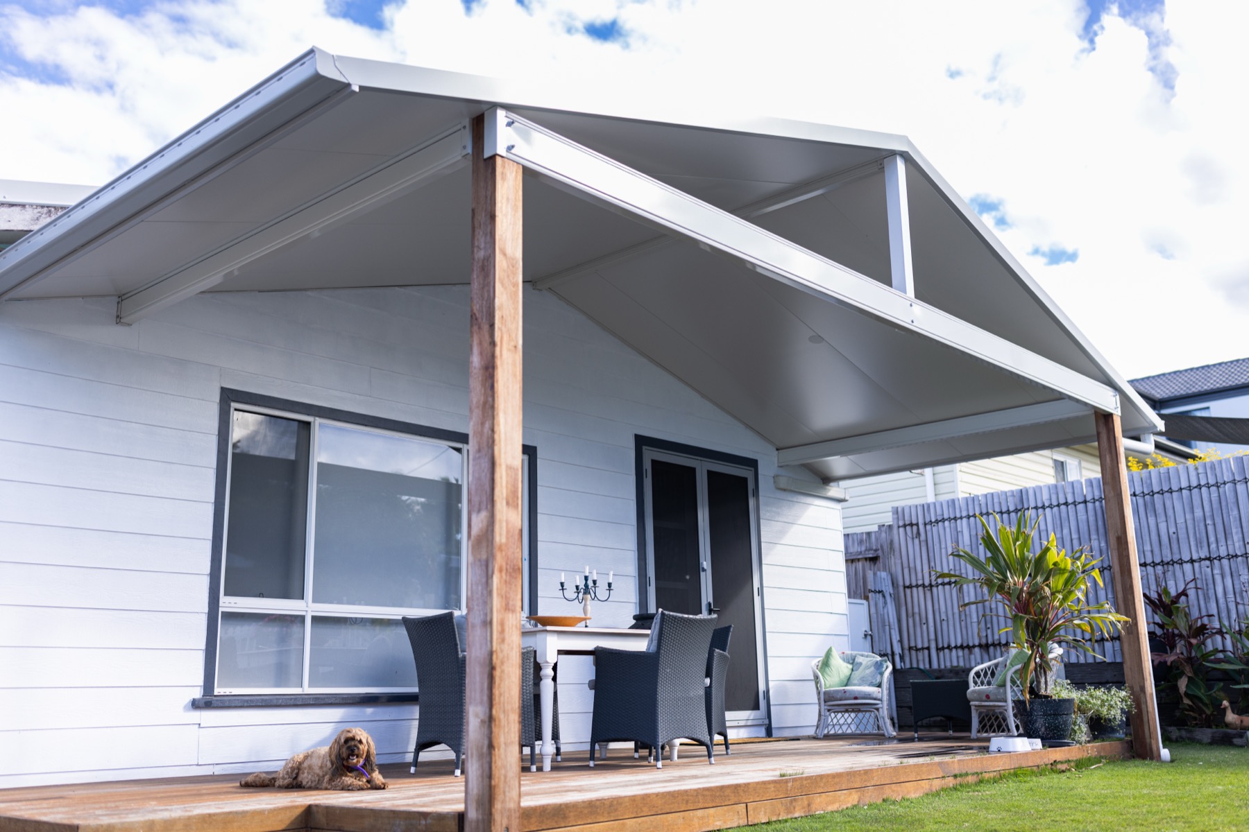 Insulated gable-roof patio with timber posts, over a timber deck at a weatherboard home